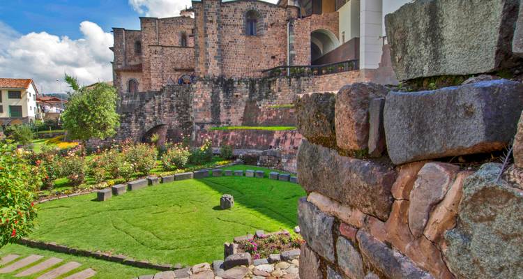 Historic courtyard with stone walls and beautiful garden.