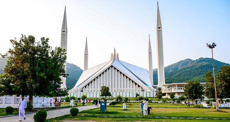 Mezquita Faisal en Islamabad con personas acercándose a la entrada.