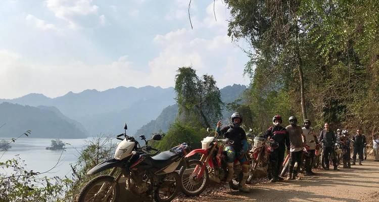Groep motorrijders die een pauze nemen bij een meer.