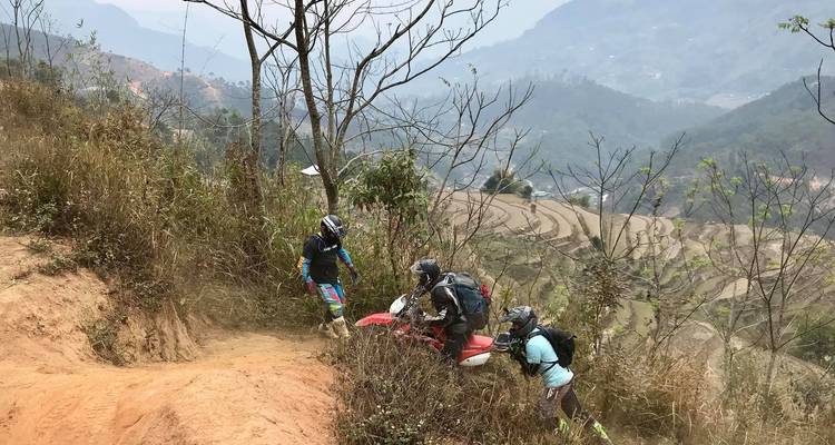 Motorrijders die elkaar helpen op een steile heuvel.