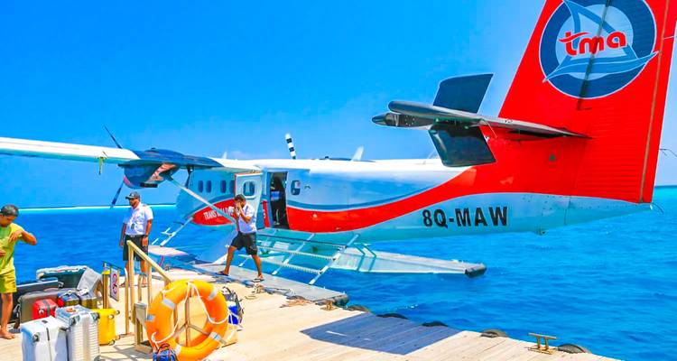 Hydravion amarré à un quai en bois au-dessus de l'océan.