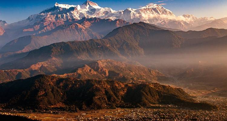 Panoramisch uitzicht op bergen met een dorp eronder.