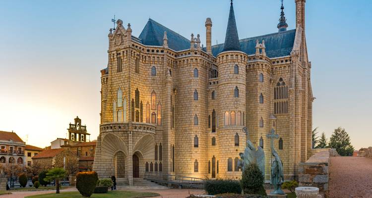 Het sprookjesachtige stenen bisschoppelijk paleis van Astorga gloeit zacht bij zonsondergang.