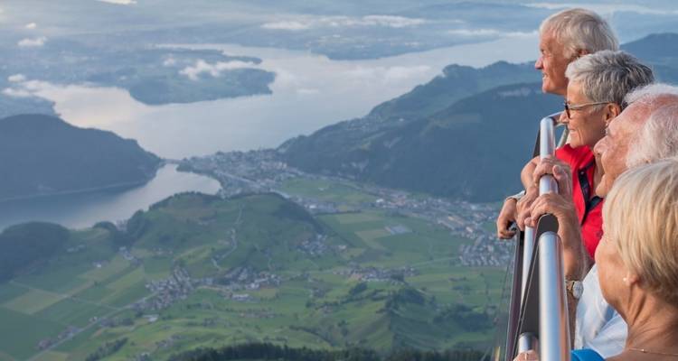 Seniorengruppe genießt eine malerische Aussicht von einem hohen Aussichtspunkt.