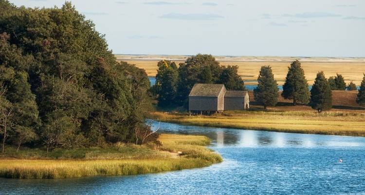 Countryside view with traditional houses and water.