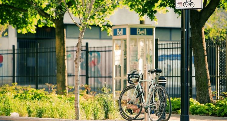 Bicycle parked near a telephone booth in an urban area.