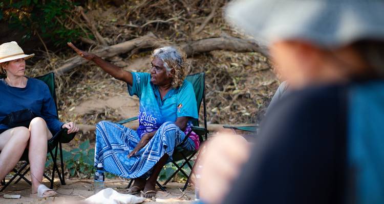People engaged in a conversation in an outdoor setting.
