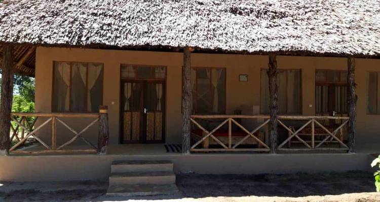 Traditionelles Gebäude mit Reetdach und Holzveranda.