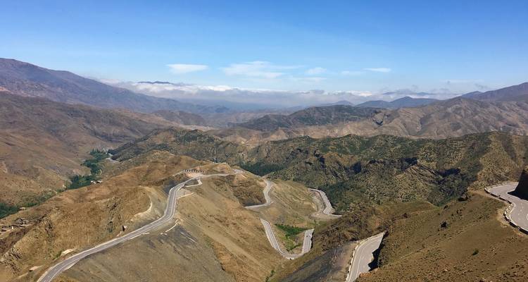 Winding roads in a mountainous landscape under blue skies.