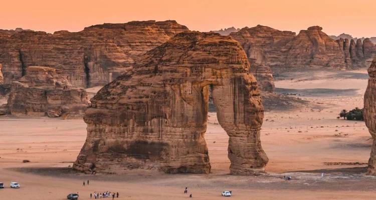 La formation en arche d'Elephant Rock s'élève des sables du désert au coucher du soleil à Al-Ula, Arabie Saoudite.