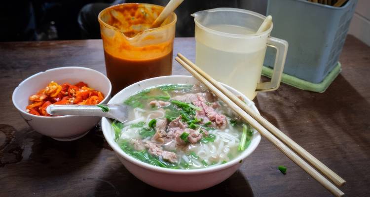 Bol de pho avec des ingrédients frais incluant des nouilles et des herbes