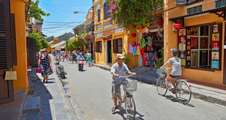 Rue colorée dans une ville animée avec des vélos et des gens qui marchent.