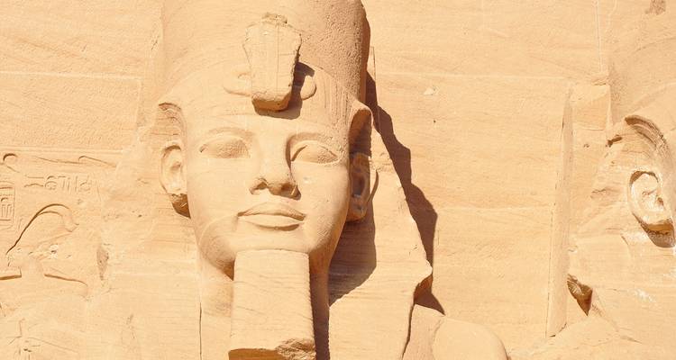 Gros plan d'une statue colossale de pharaon sculptée dans le grès à Abu Simbel.