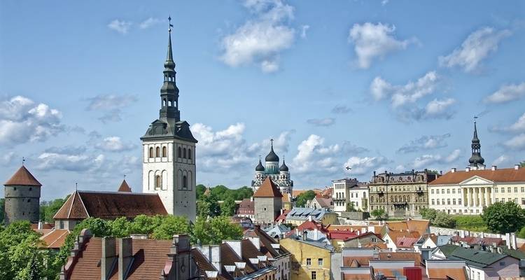 Cityscape with prominent church towers and historic buildings on a clear day.