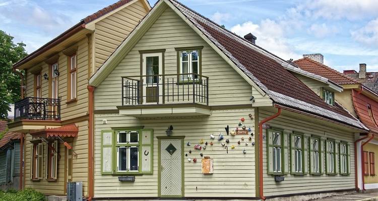 Traditional wooden house with decorative elements and a small balcony.