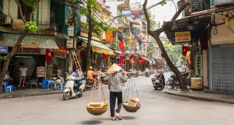 Escena bulliciosa de calle con una variedad de tiendas y motocicletas.