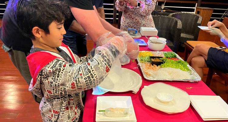 Niño preparando rollitos de primavera con ingredientes frescos.