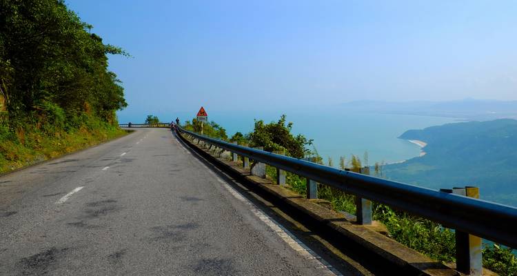 Carretera costera con una vista panorámica del océano y las montañas.