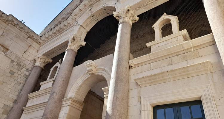 Stenen bogen en marmeren zuilen van Diocletianus' Paleis rijzen op tegen een heldere lucht.