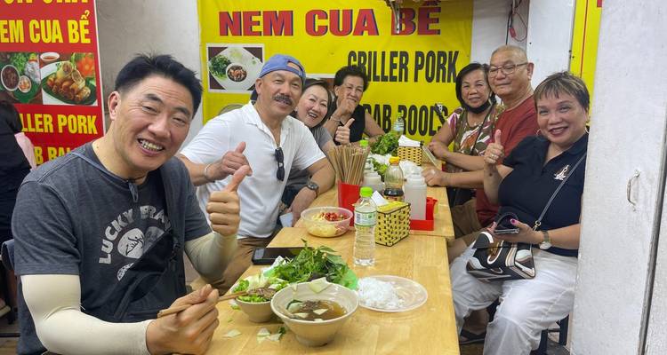Grupo disfrutando comida local en un restaurante informal.