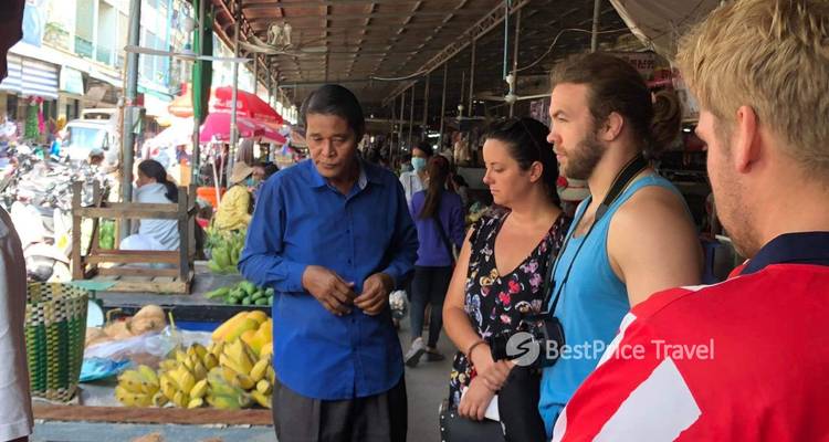 Des gens se rassemblent dans un marché animé avec diverses marchandises et produits.
