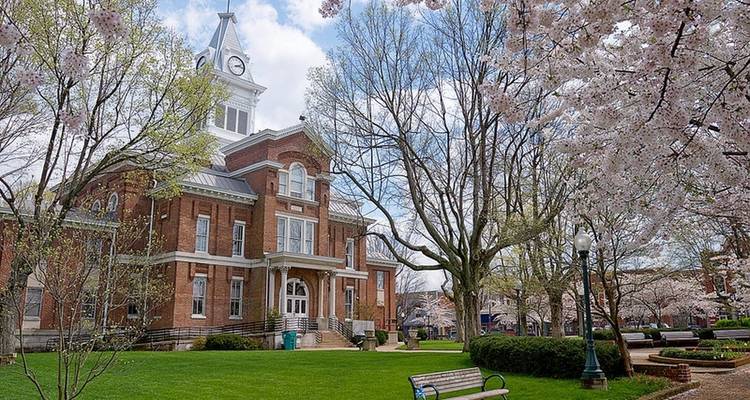 Bâtiment historique avec une tour d'horloge et un parc verdoyant