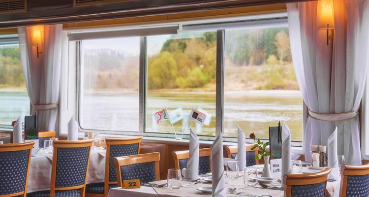 Espace de restauration avec vue sur la rivière, aménagé pour le service des repas.