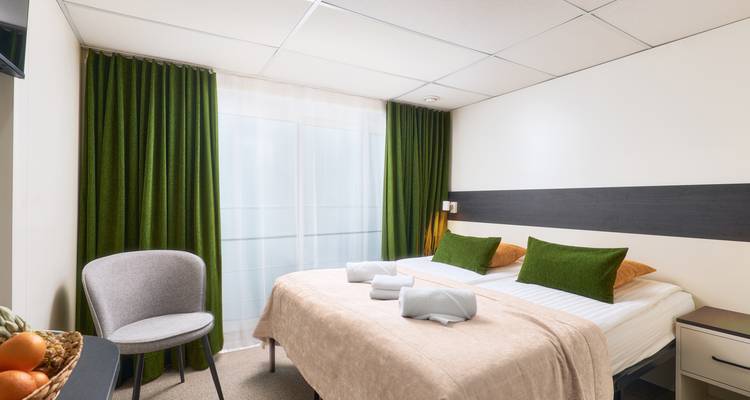 Intérieur d'une chambre d'hôtel avec lit et chaise.