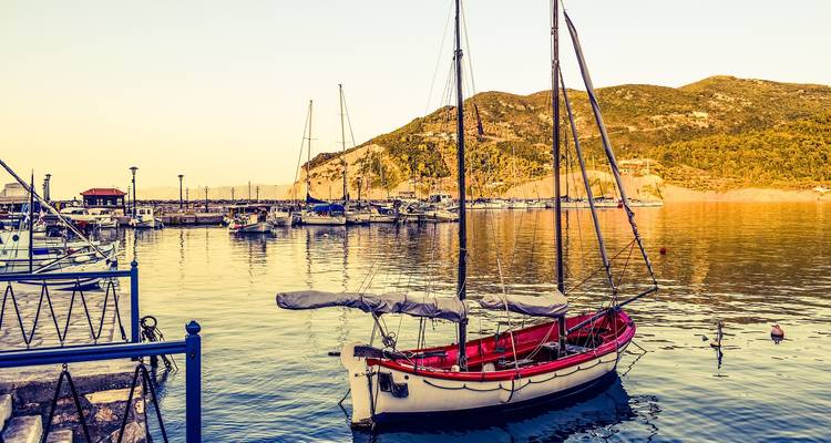 Boat docked at a tranquil marina during golden hour.