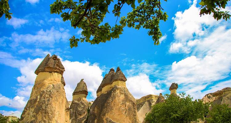Formations rocheuses inhabituelles dans un paysage semi-aride sous un ciel bleu.