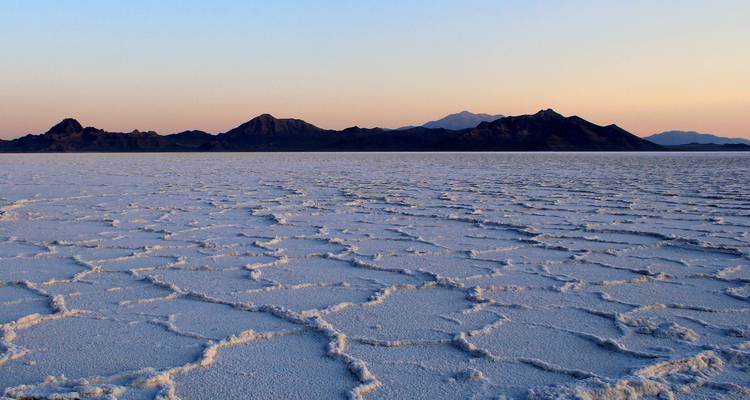 Des salines s'étendant jusqu'aux montagnes lointaines avec des motifs complexes.
