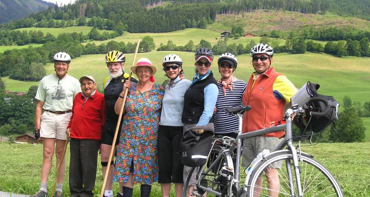 Groupe de cyclistes posant dans une zone rurale pittoresque.