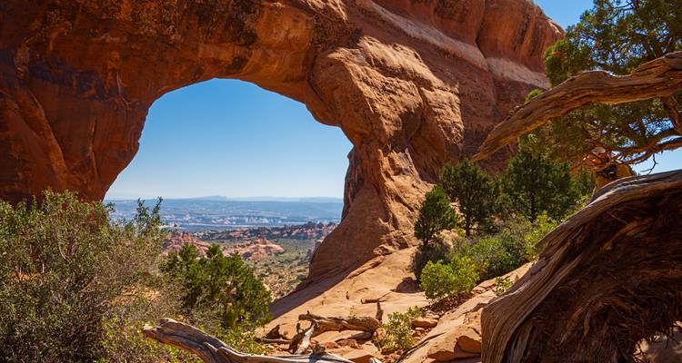 Natural rock arch with a view of a desert landscape beyond.