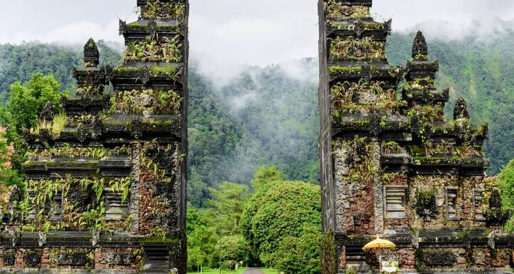 Balinese temple gate surrounded by lush green mountains.