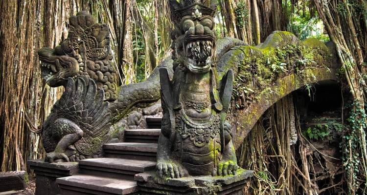 Intricate carved statues in a lush, jungle environment.