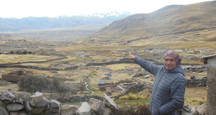 Een persoon die wijst naar een schilderachtig berglandschap.