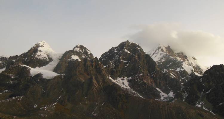 Gehavende bergtoppen met enkele wolken aan de hemel.
