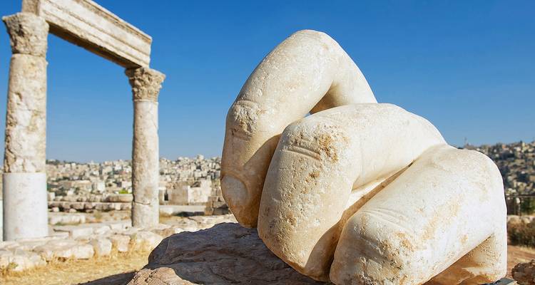 Les restes massifs d'une main en pierre sculptée et d'une colonne à la Citadelle d'Amman
