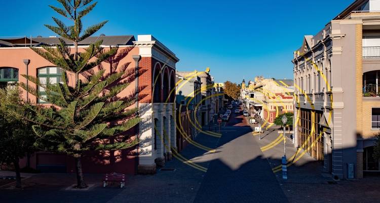 Street lined with trees and colorful buildings.