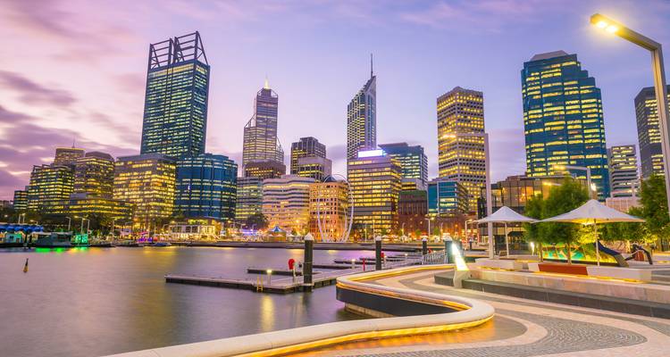 Cityscape with illuminated modern buildings at dusk.