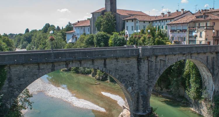 Puente histórico sobre un río con edificios antiguos.