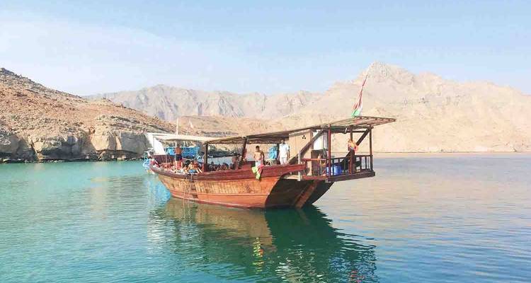 Traditionelles Dhau-Boot mit Menschen auf ruhiger See.
