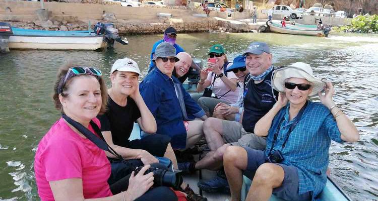 Gruppe von Menschen, die auf einem Boot auf einem Fluss sitzen.