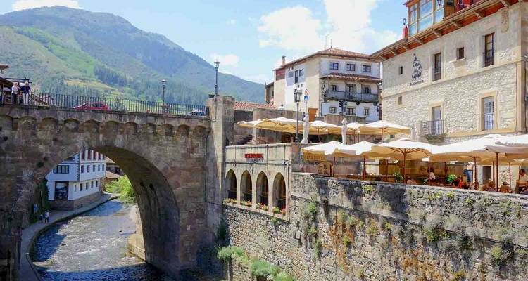 Un pont historique dans une ville avec des espaces de restauration en plein air.