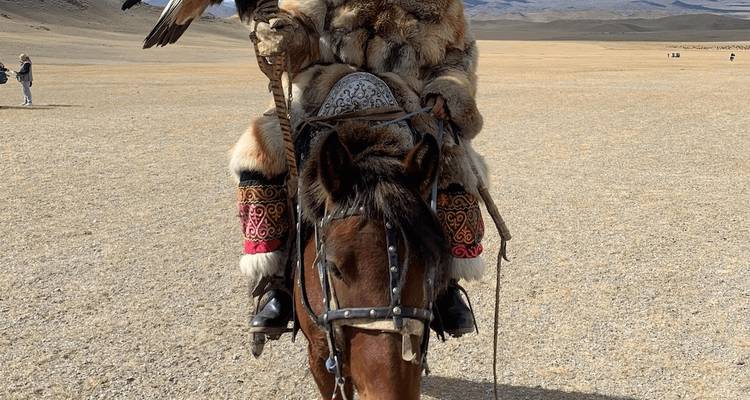 Persona con vestimenta tradicional a caballo sosteniendo un águila.