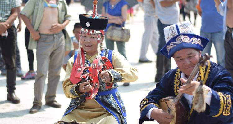 Personas con vestimenta tradicional mongola tocando instrumentos.