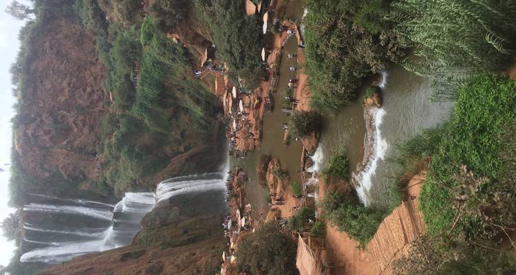 Aerial view of waterfalls and rivers with people exploring the area.