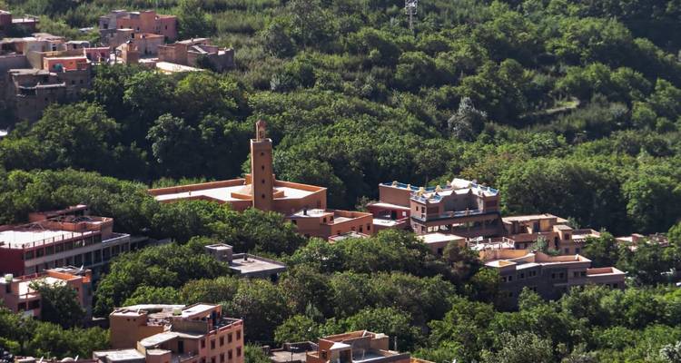 View of a village nestled among lush green hills.