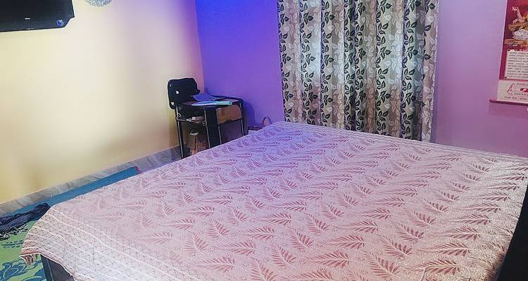 Schlafzimmer mit einem großen Bett und gemusterter Tagesdecke.