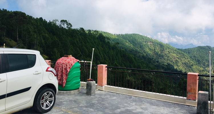 Außenparkplatz mit Auto und Bergblick.